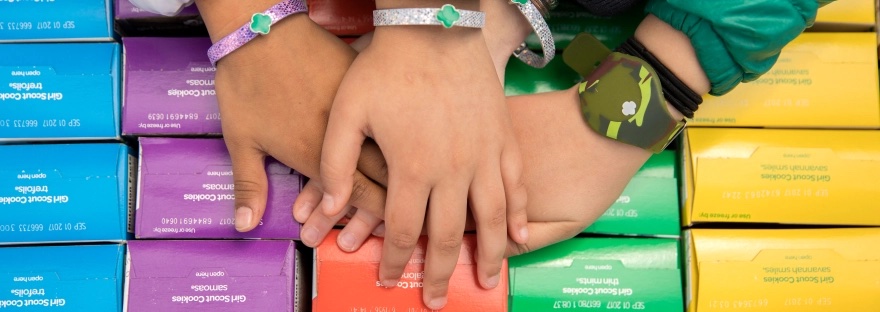 Girl scout hands on boxes of cookies